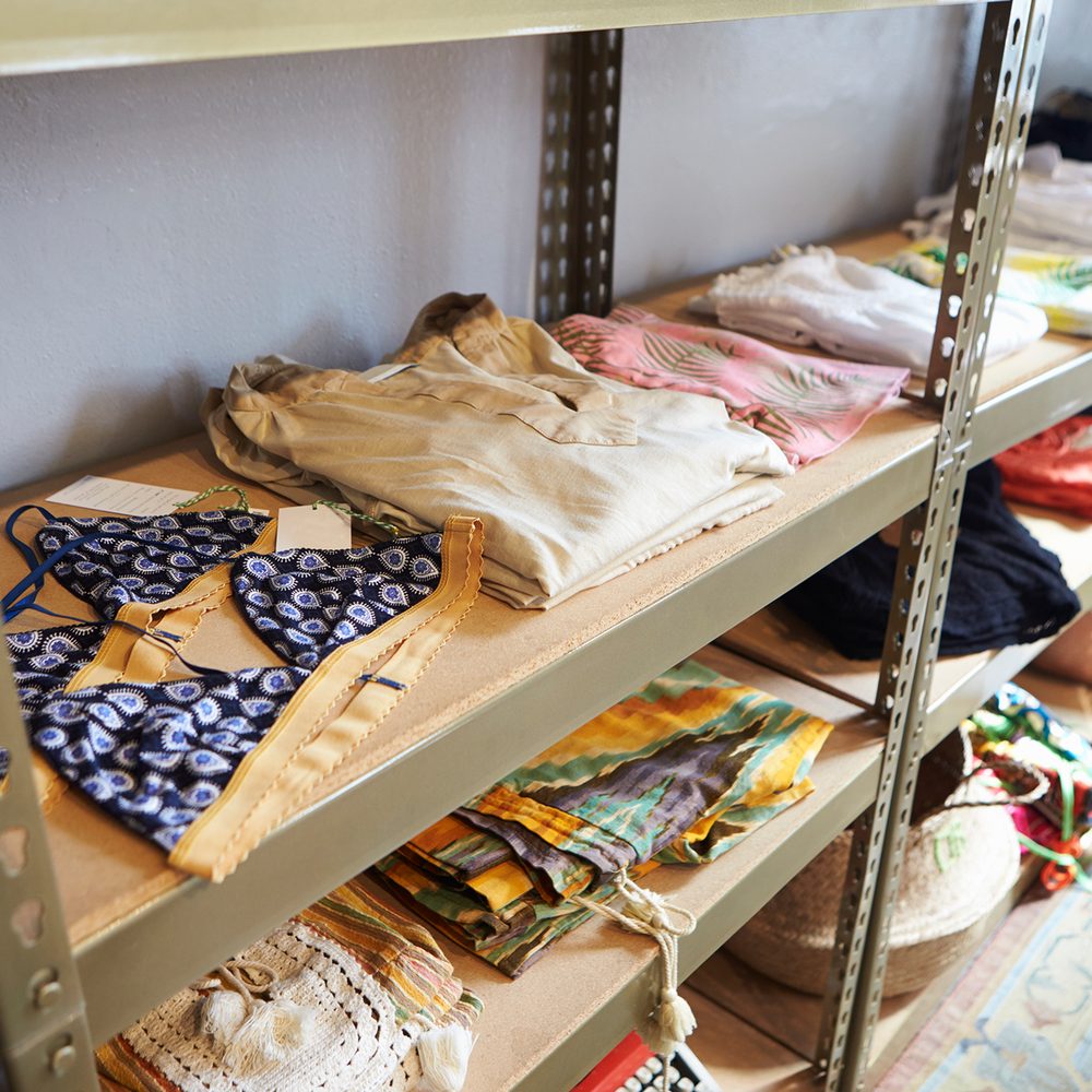 Neatly folded and sorted clothing on shelves at the community free store, ready to take. No people shown.
